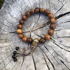 Approximately 13mm phoenix tail wood beads on brown cord wrist mala bracelet  Fits sizes 7 1/2 to 8 There is a small variation in regards to inlay brass bead. Wooden beads are approximately 12mm Spiritual Wooden Beaded Bracelets, Adjustable Wood Bracelets For Meditation, Spiritual Adjustable Natural Wood Beaded Bracelets, Adjustable Wooden Bracelet With 8mm Beads, Adjustable Wooden Beaded Bracelets With 8mm Beads, Adjustable Wooden Beaded Bracelet With 8mm Beads, Brown Wooden Bracelet With 8mm Beads, Spiritual Natural Wood Beaded Bracelets, Adjustable Wooden Beaded Bracelets For Meditation