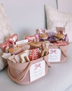 two baskets filled with personal items on top of a white couch next to a pillow