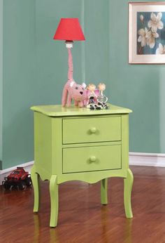 a green table with two drawers and a pink lamp on it in a blue room