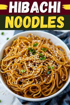 a white bowl filled with noodles and topped with sesame seeds