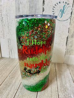 the tumbler is decorated with glitters and green, red, and white colors