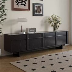 a living room scene with focus on the sideboard and vases in the foreground