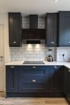 blue modern shaker kitchen cabinets with cup handles, white worktops and wooden flooring. Indigo Shaker Kitchen, Navy Blue Small Kitchen, Dark Blue Shaker Kitchen, Male Kitchen Ideas, Navy Kitchen Wooden Worktop, Kitchen Ideas Navy, Small Navy Kitchen, Blue Small Kitchen, Dark Blue And White Kitchen