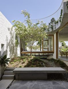 a bench sitting in the middle of a courtyard next to a building with stairs leading up to it