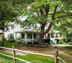 a large white house sitting on top of a lush green field