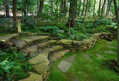 a stone wall in the middle of a garden