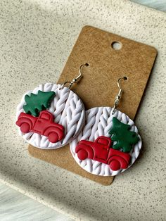 the earrings are decorated with red and green christmas trees on white braided paper circles