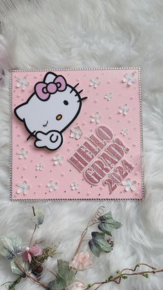 a pink hello kitty card with flowers on it and the words hello kitty written in white