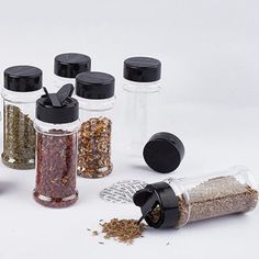 six spice jars with different types of spices and seasonings in them on a white surface