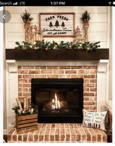 a living room with a fire place and christmas decorations on the mantel above it