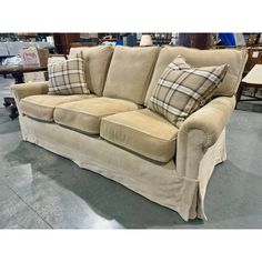 a tan couch with plaid pillows on it