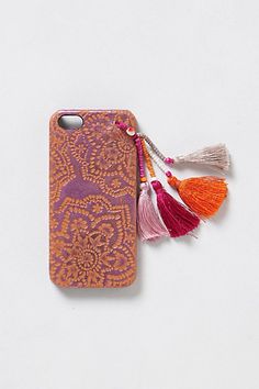 an orange and purple case with tassels on it, sitting next to a white background