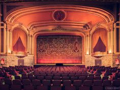 an empty theater with rows of seats facing the stage