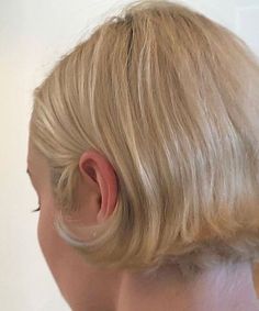 the back of a woman's head with short blonde hair and an ear piercing