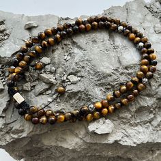 Our Summit Necklaces, are handcrafted from premium natural stones found deep under the surface of earth, will inspire you to reach your highest potential with powerful manifestations and meaningful styles. Featuring a strong nylon string and finished with a stainless-steel drawstring lock, necklace slides over the head for easy transitions and offers versatile styling options. Tiger’s Eye Gemstones, 6mm Properties: Strength, Confidence, Power Trident Symbol Beads Stainless Steel, 6mm Stainless S Adjustable Crystal Necklace With 108 Beads For Healing, Spiritual Necklace With Adjustable Cord, Adjustable Brown Hand-strung Necklaces, Adjustable Hand-strung Holistic Necklace, Adjustable Hand-strung Brown Necklace, Brown Adjustable Hand-strung Necklace, Adjustable Spiritual Beads With Natural Stones, Adjustable Spiritual Natural Stone Beads, Spiritual Beaded Bracelets With Round Beads And Adjustable Cord