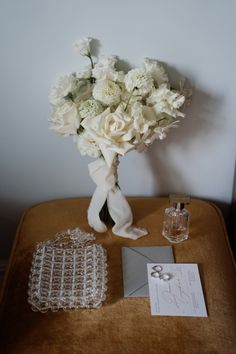 a bouquet of white flowers sitting on top of a table next to a card holder