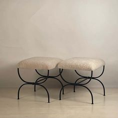 two stools sitting on top of each other in front of a white wall and floor