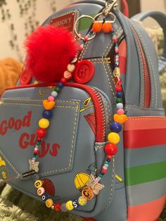 a backpack with a red pom - pom attached to it