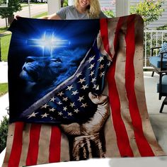 a woman holding up a large blanket with an image of jesus and a lion on it