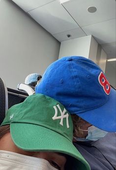 a man wearing a new york yankees baseball cap and mask in an airport waiting area