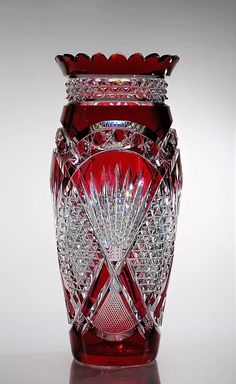 a red glass vase sitting on top of a table