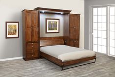 a bed sitting in a bedroom next to a wooden dresser and wardrobe with doors open