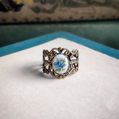 This Victorian vintage style ring is fully adjustable and available in antiqued brass or silver plate. The 8x10mm porcelain rose cameo is antique. Choose from Pink, Blue, or Yellow. Don't forget to grab a pair of matching earrings, necklace, or locket from my store to complete the look. Vintage Enamel Rings For Gifts, Handmade Enamel Vintage Rings, Vintage Cameo Jewelry In Enamel, Vintage Adjustable Cameo Jewelry, Vintage Cameo Enamel Jewelry, Vintage Adjustable Cabochon Jewelry, Vintage Enamel Cameo Jewelry, Adjustable Vintage Cabochon Jewelry, Vintage Enamel Cabochon Rings