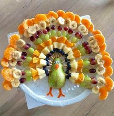 a turkey made out of fruit on top of a white plate