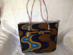 "Make a statement with this beautiful and stunning tote bag. This gorgeous tote was made with high quality African fabric print. This ankara bag would complete your outfit for every occasion, everyday casual wear. This Ankara tote made from African wax fabric with top zipper closure and inside pocket with zipper. It is fully lined It also has back pocket with zipper. Tote includes an inside pocket with zipper to keep items organized Dimensions: length 10\" by width 15\" by 4\" depth. The handle African Fabric Accessories, Ankara Bags, Fabric Purse, Wax Fabric, Fabric Purses, Fabric Tote, Fabric Accessories, African Print Fabric, Ankara Fabric