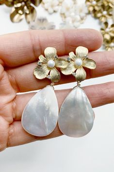 These statement bridal earrings will turn heads as you walk down the aisle. Featuring mother of pearl teardrop earrings with a gold flower stud base. Classic and modern wedding jewelry for brides, bridesmaids, and mother of brides. Wear these pearl teardrop wedding earrings for your rehearsal dinner, bridal shower, and your wedding for a touch of timeless elegance. Shop all your bridal jewelry needs at shopkateandmari.com. Glamorous Teardrop Pearl Earrings, Glamorous Teardrop Pearl Earrings For Pierced Ears, Chic Teardrop Pearl Earrings For Party, Mother Of Pearl Dangle Pearl Earrings, Chic Silver Teardrop Pearl Earrings, Elegant Teardrop Mother Of Pearl Earrings, Party Pearl Drop Earrings In Mother Of Pearl, Party Pearl Teardrop Earrings, Chic Teardrop Pearl Earrings For Pierced Ears