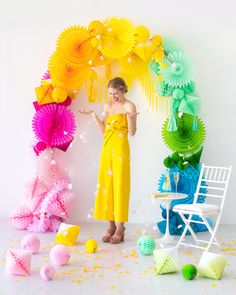 a woman standing in front of some paper decorations