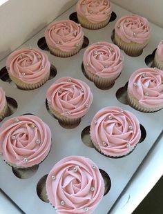 cupcakes with pink frosting in a white box