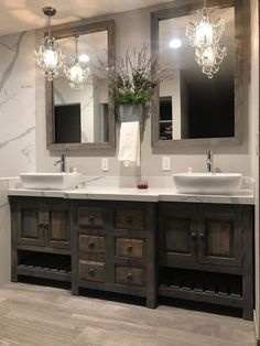 a bathroom with double sinks and two mirrors on the wall next to eachother