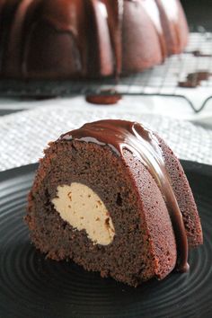 a chocolate bundt cake on a black plate with a bite taken out of it