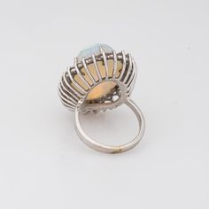 Stylish vintage natural opal ring (circa 1970s to 1980s) crafted in 14 karat white gold.   Natural opal measures 22mm x 14.5mm (estimated at 22 carats). The opal is in very good condition and free of cracks or crisps. Round brilliant cut diamonds total an estimated 1.40 carats (estimated at H-I colour and VS2-SI1 clarity).   The opal is full of colour and fire (opals are difficult to photograph and the true colours of the opal does not show in the pictures). The colour matrix is vivid from merma Oval Opal Rings With Polished Finish, Formal Hallmarked Opal Ring, Formal Opal Birthstone Ring, Formal Hallmarked Oval Cabochon Opal Ring, Hallmarked Oval Opal Ring, Oval White Gold Opal Cabochon Ring, Oval Cabochon White Gold Opal Ring, Formal Opal Oval Cabochon Ring, Oval Cabochon Opal Ring In White Gold