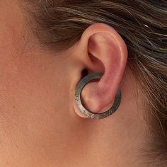 Here you may see a truly modern cuff that will definitely make a statement on your ear! Hoops with a special twist. You may wear it all day long as it comfortably stays stable. Of course, there is always the option to wear it as a big stud open circle earring! Black rhodium plated on raw sterling silver base with a satin finish. You just need an earlobe piercing to wear them and PLEASE BE ABSOLUTELY SURE THAT THE SIZE OF THE CUFF FITS YOUR EAR! Every ear is unique so please measure your ear befo Modern Internally Threaded Adjustable Earrings, Modern Adjustable Single Cartilage Earring, Adjustable Modern Single Wrap Earring, Modern Adjustable Single Wrap Earring, Modern Adjustable Cartilage Earrings With Ear Wire, Modern Cartilage Earrings With Ear Wire, Modern Metal Pierced Ear Cuff, Modern Nickel-free Ear Cuff As Gift, Modern Pierced Round Ear Cuff