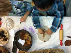 two young boys are making paper plates with leaves