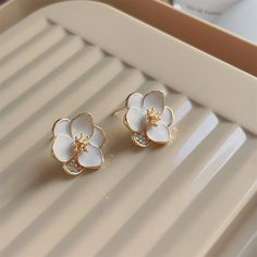 A pair of floral stud earrings designed with 18k gold-plated trim and cubic zirconia accents. 0.78" W x 0.82" H 18k gold-plated copper / cubic zirconia / enamel Floral Studs, Designer Earrings, Cubic Zirconia, 18k Gold, Gold Plate, Copper, Plating, Stud Earrings, Trim