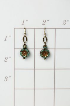 A symbol of peace and beauty, these handmade flower dangle earrings created with Czech glass and antique brass. Antique brass earwires (lead- and nickel-free) Czech glass Approximately 1.5" length Our unique handmade designer jewelry for women is made in America, each design created individually in our personal design studio in Floyd VA USA Brass Flower Drop Earrings, Copper Drop Earrings With Flower And Ear Wire, Nickel-free Round Brass Flower Earrings, Copper Drop Flower Earrings With Ear Wire, Nickel Free Czech Glass Flower Earrings, Nickel-free Czech Glass Flower Earrings, Gold Nickel-free Czech Glass Flower Earrings, Nickel-free Gold Czech Glass Flower Earrings, Nickel-free Gold Flower Earrings With Czech Glass