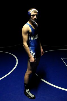 a man standing on top of a wrestling ring wearing a blue suit and headband