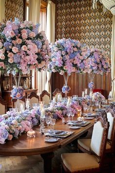 a dining room table is set with flowers and candles for an elegant dinnereon party