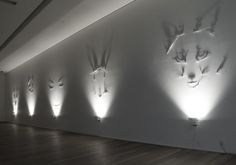 the wall is lined up with several animal heads on it's sides, and there are many lights shining in between them