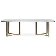 an oval glass table with gold legs and a metal frame around the edge, against a white background