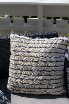 a blue and white pillow sitting on top of a chair