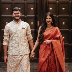 a man and woman holding hands while standing next to each other