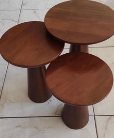 three wooden tables sitting on top of a tiled floor