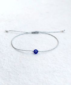 Silver evil eye bracelet, Evil eye bracelet, Dainty bracelet, Tiny silver bracelet, Minimalist bracelet, Greek mati bracelet Handmade bracelet with tiny evil eye on silver waxed string. A dainty and simple but elegant bracelet for women, men, children for everyday, as it is durable and water resistant. Also perfect for layering. ★ Details * Dark blue or light blue evil eye glass charm 6mm * Silver plated beads 3mm * Silver waxed string 1mm * Adjustable size with macrame sliding knot ★ Size Adjus Simple Tiny Adjustable Bracelets, Delicate Adjustable Simple Bracelets, Tiny Adjustable Sterling Silver Bracelets, Adjustable Evil Eye Bracelet For Everyday, Adjustable Silver Evil Eye Friendship Bracelets, Handmade Minimalist Evil Eye Bracelet, Minimalist Evil Eye Bracelet With Adjustable Chain As Gift, Adjustable Silver Beaded Bracelet With Evil Eye, Handmade Silver Evil Eye Bracelet For Friendship