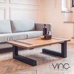 a living room with a couch, coffee table and vase on the floor in front of it