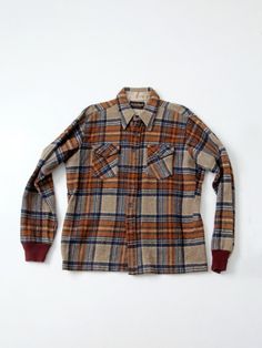 "This is a 1970s vintage The King Size Co plaid flannel shirt.  The woolly shirt jac features a brown and blue plaid pattern and brown ribbed cotton cuffs.  It buttons closed and has pockets on the chest.  70% Wool, 30% Nylon CONDITION In good condition with wear consistent with age and use.  MARKED SIZE:  XXL MEASUREMENTS Bust:  51\"  ..  129.5 cm Length:  30\"  ..  76.2 cm Shoulders:  19\"  ..  48.3 cm Outside Sleeve:  28\"  ..  71.1 cm 223224" Wool Flannel Shirt With Long Sleeves For Winter, Wool Flannel Long Sleeve Shirt For Winter, Winter Wool Long Sleeve Flannel Shirt, Fitted Long Sleeve Flannel Shirt For Winter, Fitted Collared Flannel Shirt For Winter, Casual Plaid Wool Top, Wool Button-up Flannel Shirt For Fall, Wool Flannel Button-up Shirt For Fall, Fall Wool Button-up Flannel Shirt