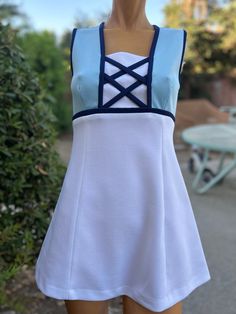 Here is a vintage 1970s polyester tennis dress.Made by Top Seed.Following  are the measurements. Bust 34",waist 30",hips 40",Length 29".Zips up the back.White skirt w Baby blue bodice.Navy Blue  Criss Cross design.One pocket on the back.In nice vintage condition Please take special consideration of measurements. 1970s sizing was very small to today's standards. Tennis dresses were very short not like a regular dress. So please take special note of length. If you live overseas please email me first before purchasing for mailing cost. Price quoted is for USA only Spring Fitted Blue Tennis Dress, Fitted Blue Spring Tennis Dress, Fitted Blue Tennis Dress For Spring, Blue Spring Tennis Dress, Blue Tennis Dress For Spring, Spring Blue Tennis Dress, Fitted Tennis Dress For Summer, Fitted Cotton Tennis Dress, 1970s Fitted White Dress